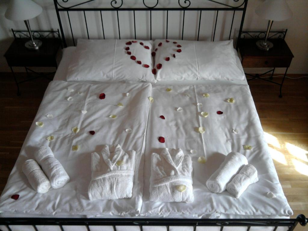 una cama con sábanas blancas y calcetines y corazones en ella en Hotelový a jezdecký areál Dvůr Krutěnice, en Krutěnice