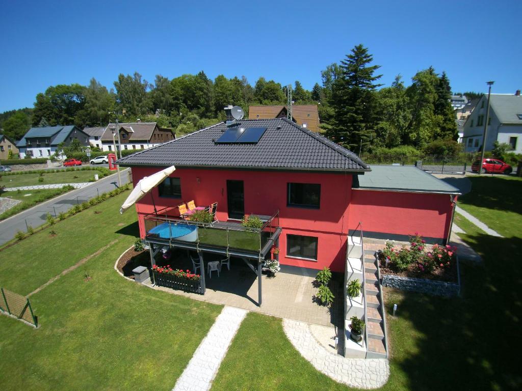 een uitzicht op een rood huis met een veranda bij Ferienwohnung Rinno in Olbernhau