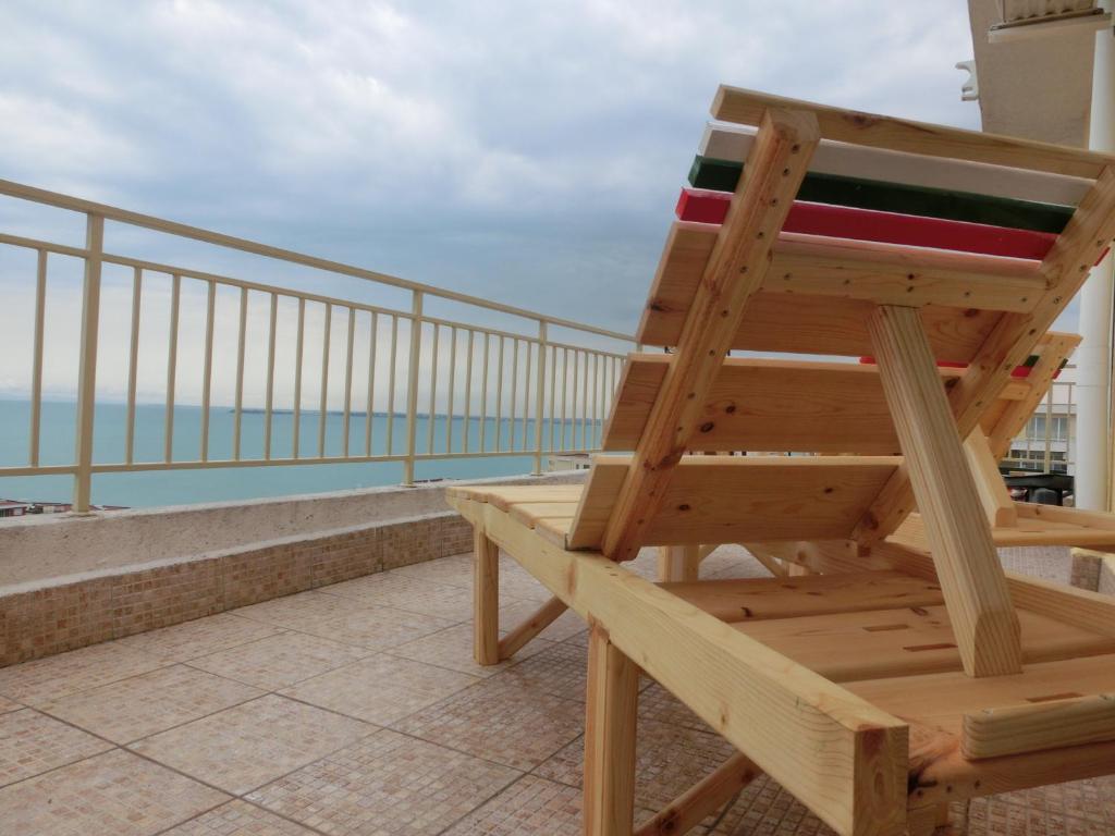 einen Holzstuhl auf dem Balkon in der Unterkunft Panoramic Sea View Apartment Crown, Pools and Beach, Sveti Vlas in Sweti Wlas