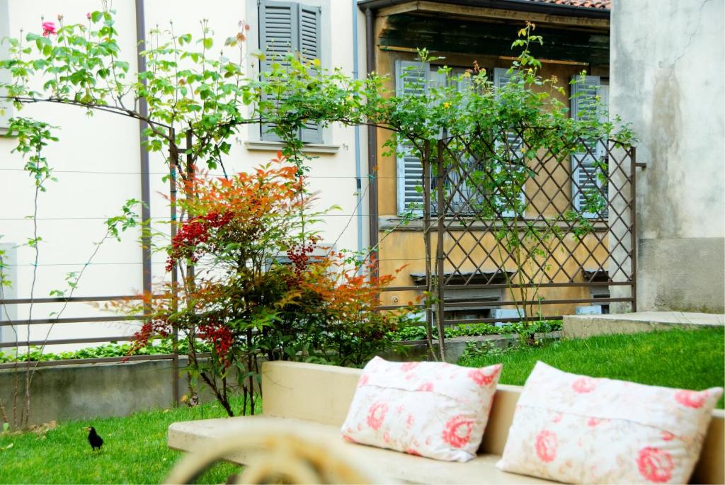 una panchina in un cortile con fiori e piante di Botton d'Oro Pelabrocco a Bergamo