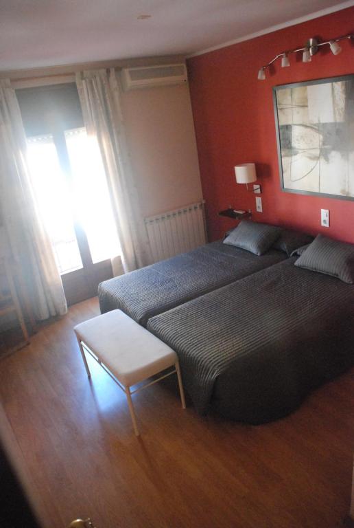 um quarto de hotel com duas camas e uma mesa em Hostal Delgado em Benabarre