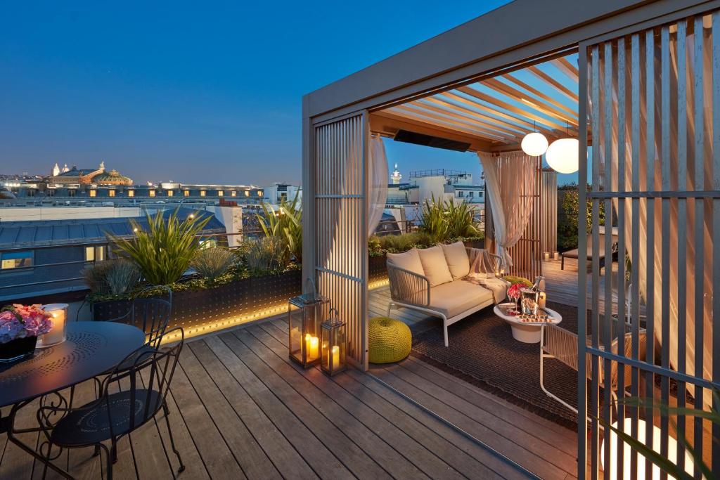 a deck with a couch and a table on a balcony at Mandarin Oriental, Paris in Paris