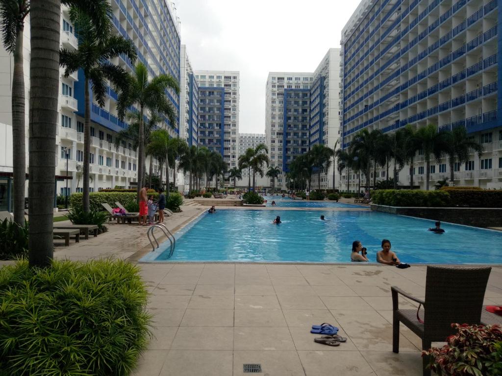 ein Schwimmbad in der Mitte einer Stadt mit Gebäuden in der Unterkunft Chin's Place Sea Residences MOA in Manila