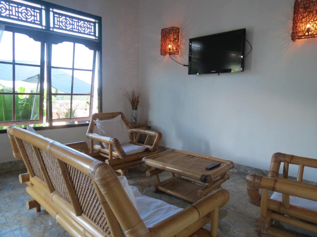 sala de estar con sillas y TV de pantalla plana en Lemon House, en Padangbai