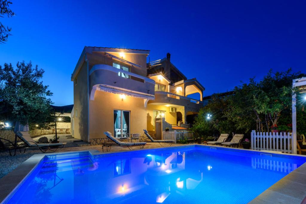 a swimming pool in front of a house at night at Studios Slaven in Plano