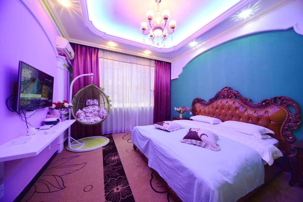 1 dormitorio con 2 camas y paredes rosas y moradas en Emeishan Moon Bay Hotel, en Emeishan