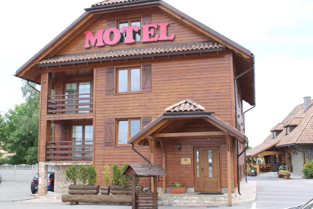 a wooden building with a motel sign on it at Pod Strzechą in Malawa