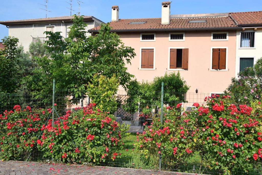 una casa con flores delante de una valla en Casa di Karim, en Pescantina