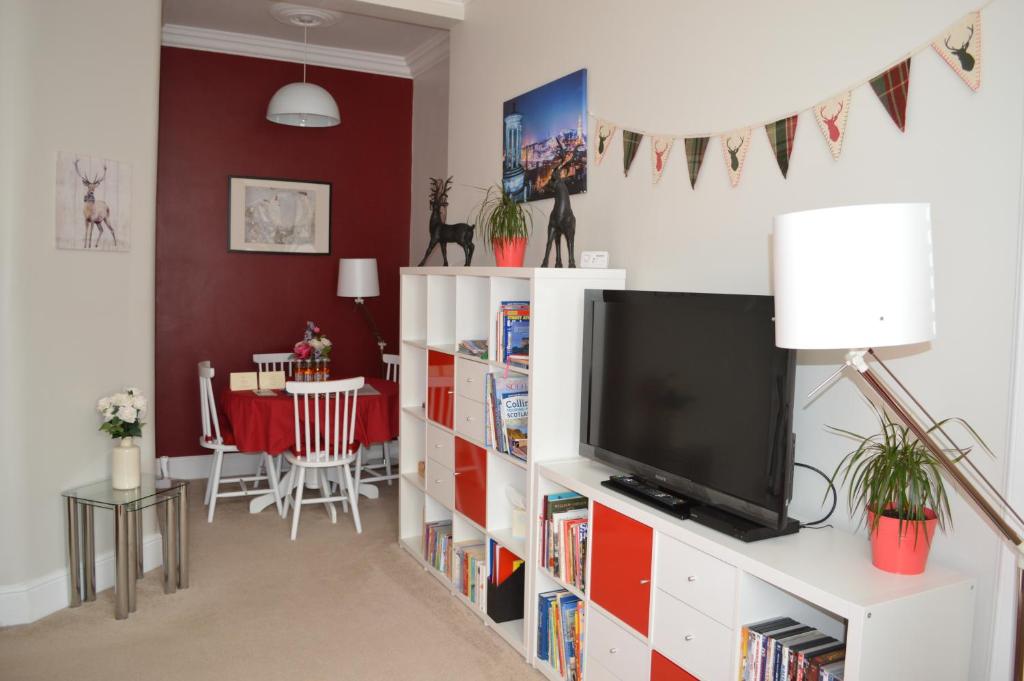 uma sala de estar com televisão e uma sala de jantar em Hamish's Hame Edinburgh Licence No EH 69774 P em Edimburgo