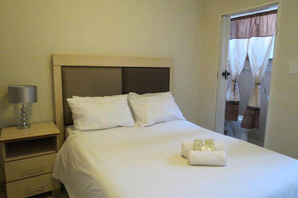1 dormitorio con 1 cama blanca y 2 toallas en Bed and breakfast Newlife BNB en Edenvale