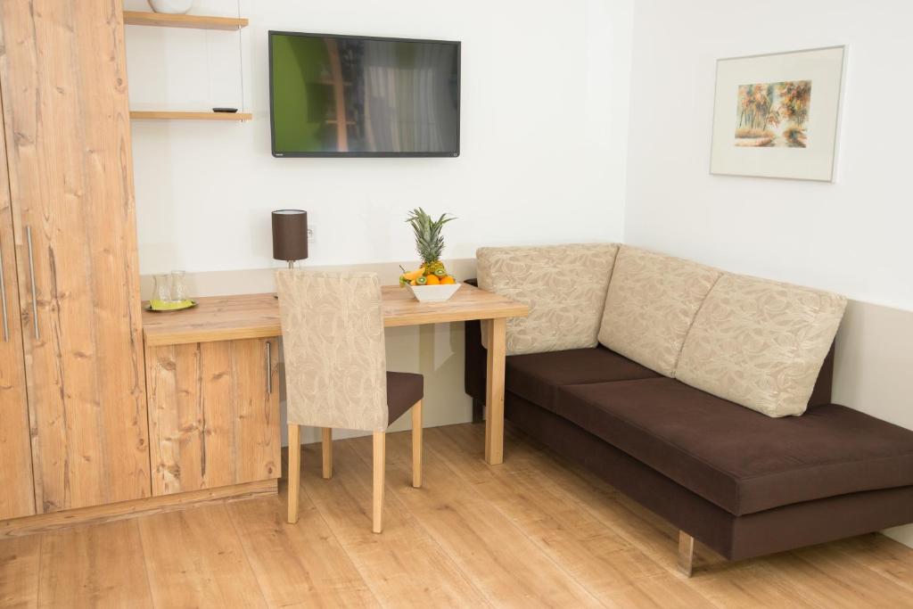 Zimmer mit einem Tisch, einem Sofa und einem Schreibtisch in der Unterkunft Lorenzerhof in Sankt Lorenzen am Wechsel