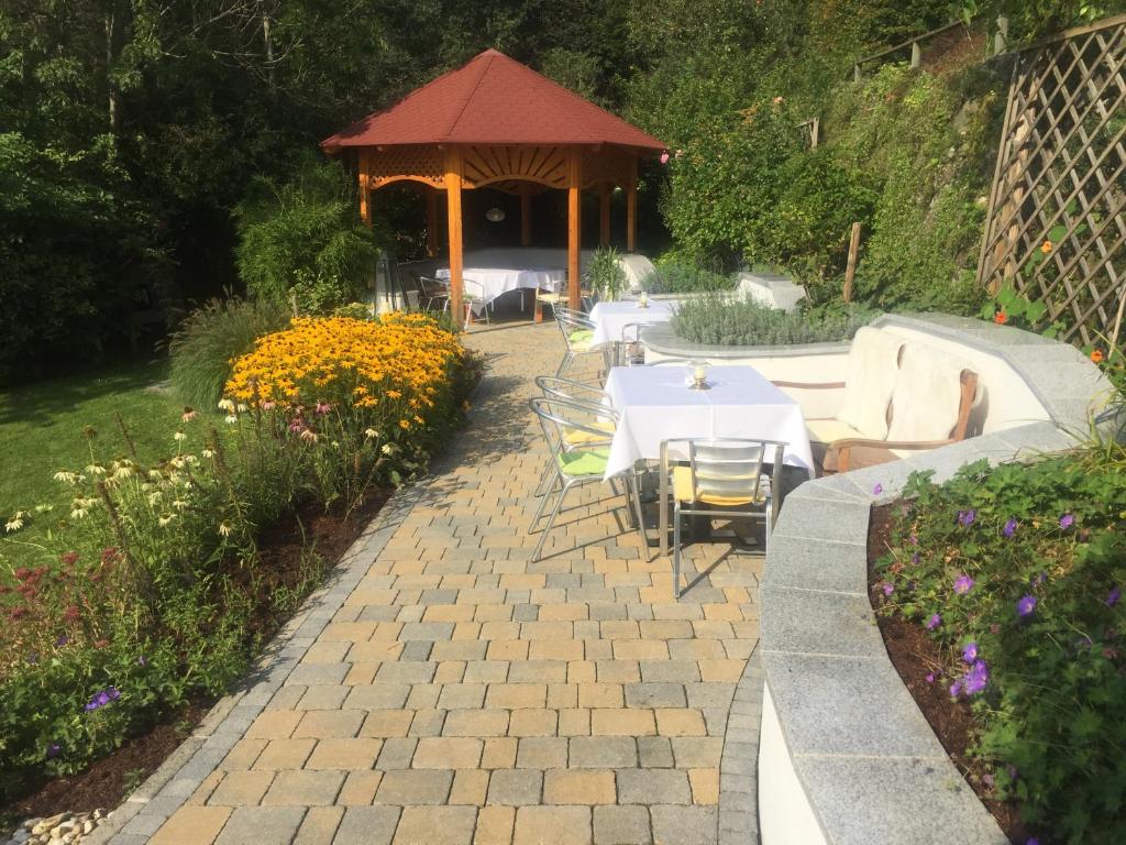 eine Terrasse mit Tischen, Stühlen und einem Pavillon in der Unterkunft Lorenzerhof in Sankt Lorenzen am Wechsel