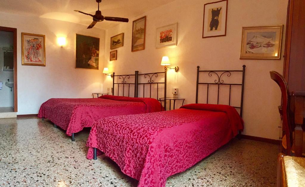 two beds in a room with pink blankets at Antica Locanda Montin in Venice