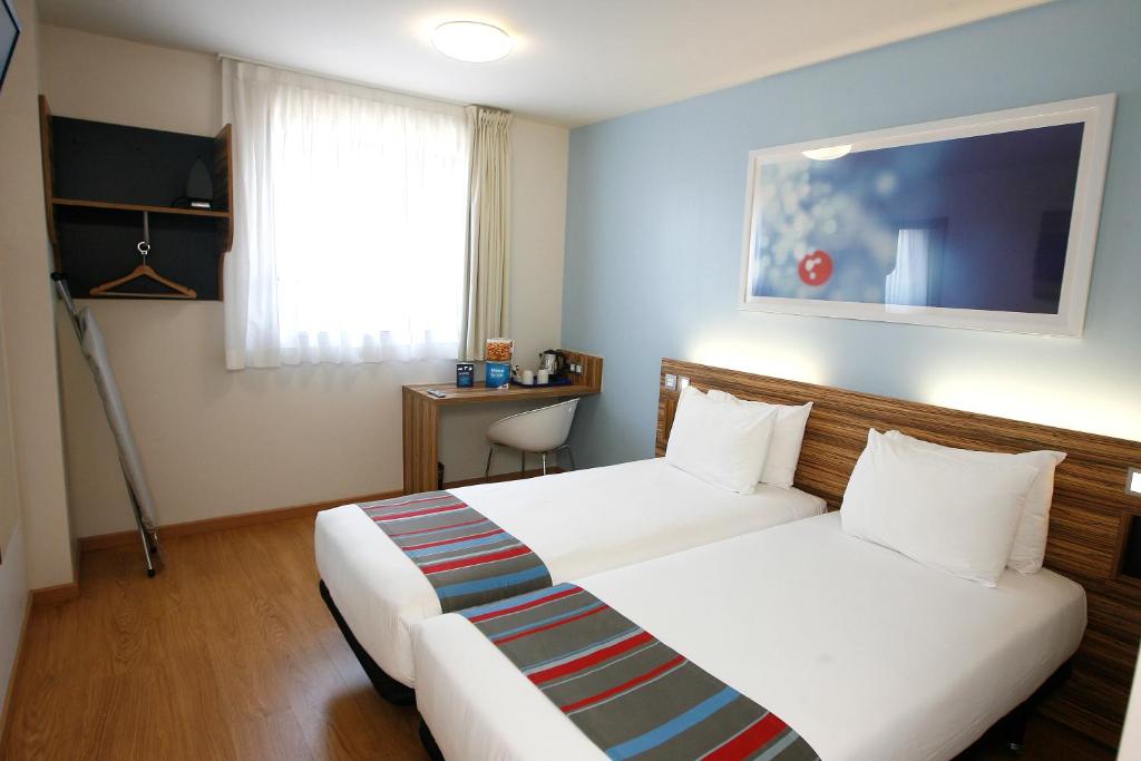 um quarto de hotel com duas camas e uma janela em Travelodge Valencia Aeropuerto em Manises