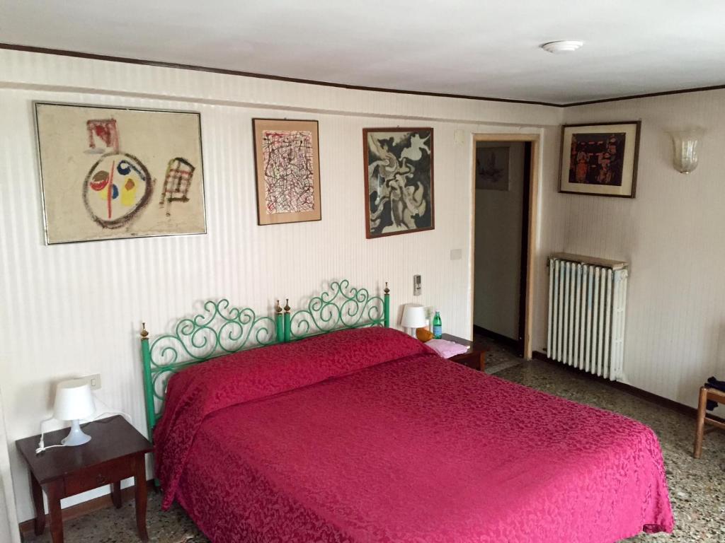 1 dormitorio con 1 cama con colcha roja en Antica Locanda Montin, en Venecia