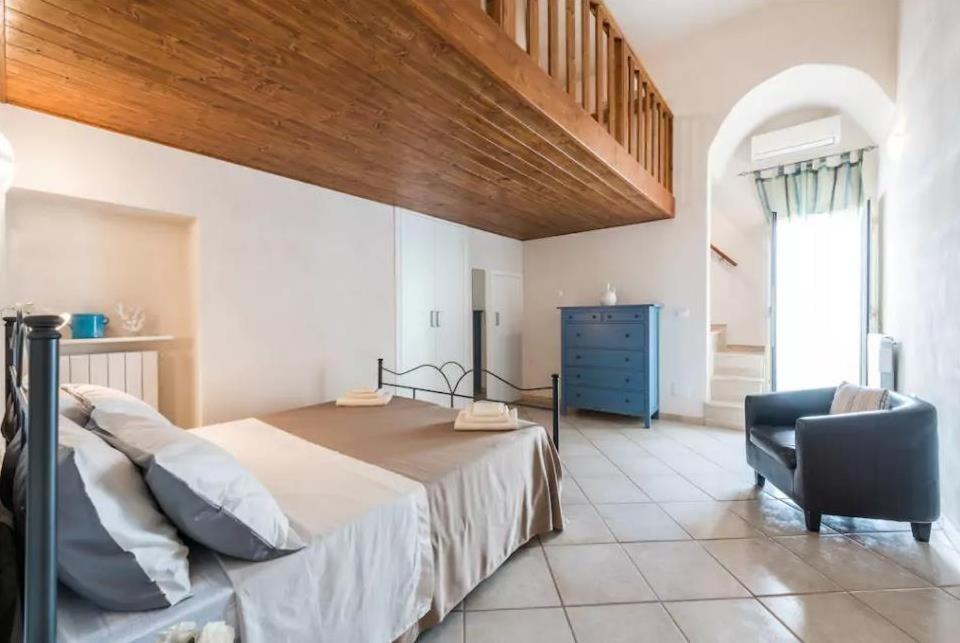 a bedroom with a large bed and a chair at Domus Chiara in Monopoli