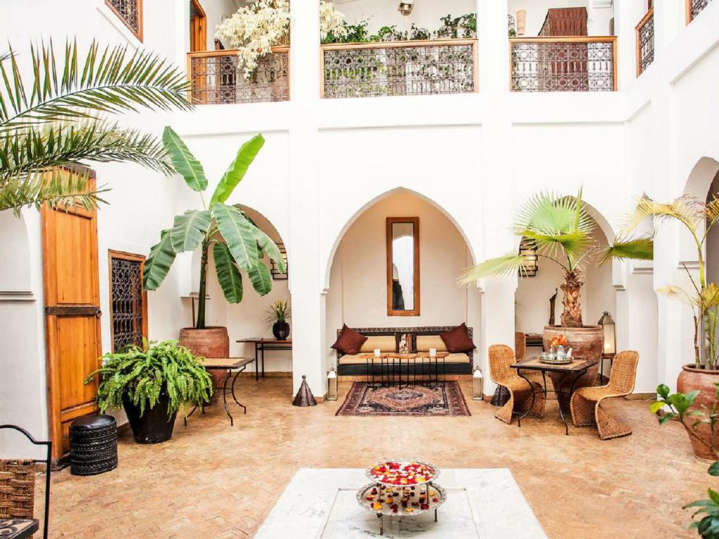 馬拉喀什的住宿－米斯奇摩洛哥傳統庭院住宅，客厅拥有棕榈树和沙发