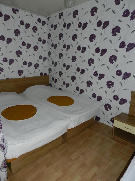 a bedroom with a bed with a floral wallpaper at Letovishte Romantika in Kamchia