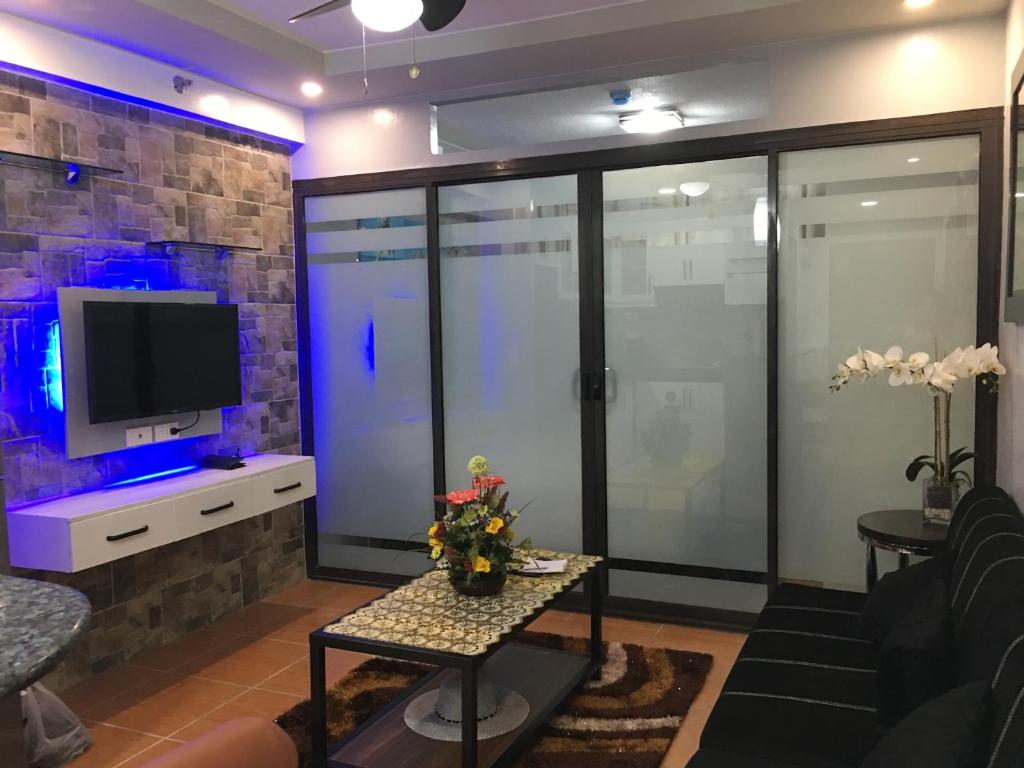 un soggiorno con TV e tavolo di Bords Sweet Home a Davao