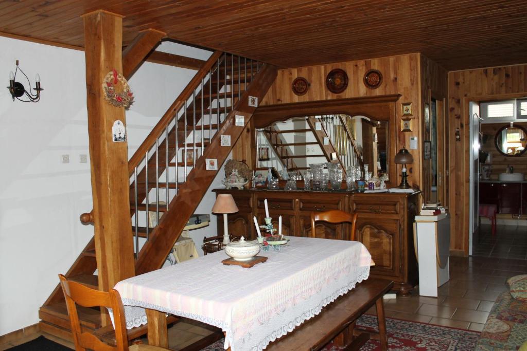 ein Esszimmer mit einem Tisch und einer Treppe in der Unterkunft Chambre d'Hôtes "Orchidees" in Nogent-le-Rotrou