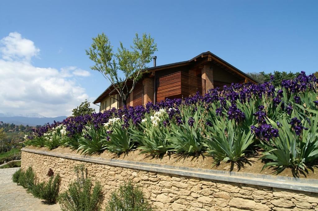 un jardin de fleurs violettes et blanches devant une maison dans l'établissement Residenza la beccata, à Pignerol