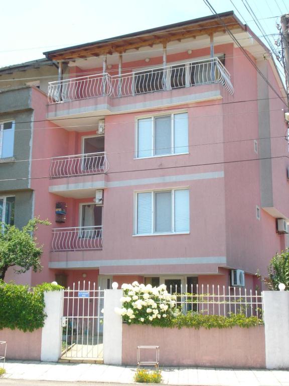 a pink building with a fence in front of it at The Sunny Home Guesthouse in Chernomorets