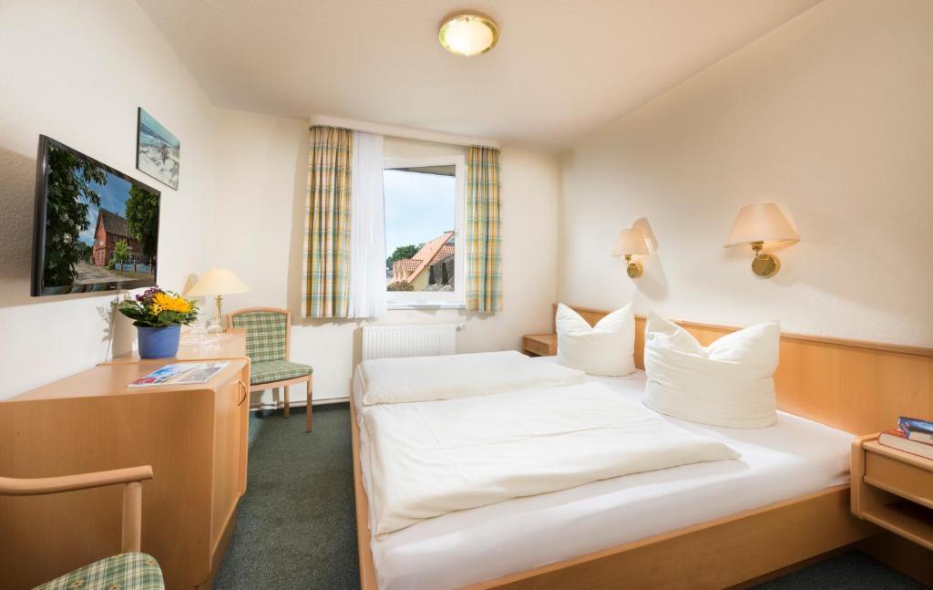 プレローにあるFrühstückspension Landhaus Langeのベッドとデスクが備わるホテルルームです。