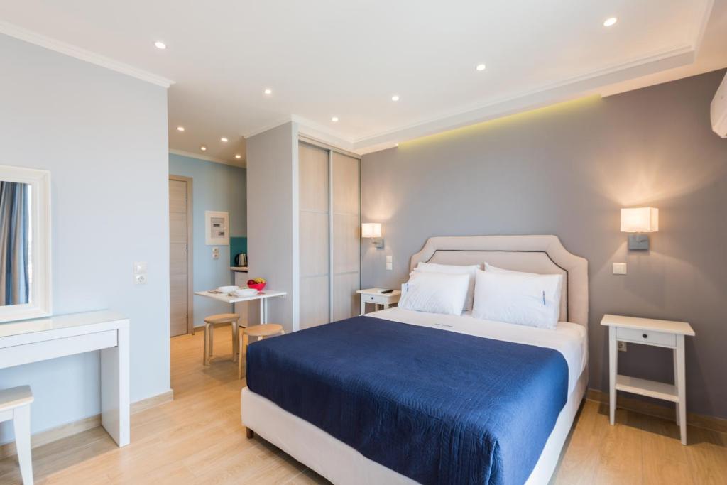 a bedroom with a large bed with a blue blanket at Pansion Ermioni in Skala