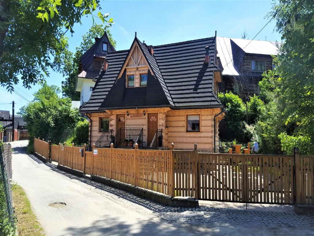 a wooden fence in front of a house at TatryTop Domek Miód Malina in Zakopane