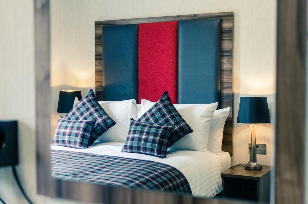 a bedroom with a bed with blue and red at Argyll Apartments in Glasgow
