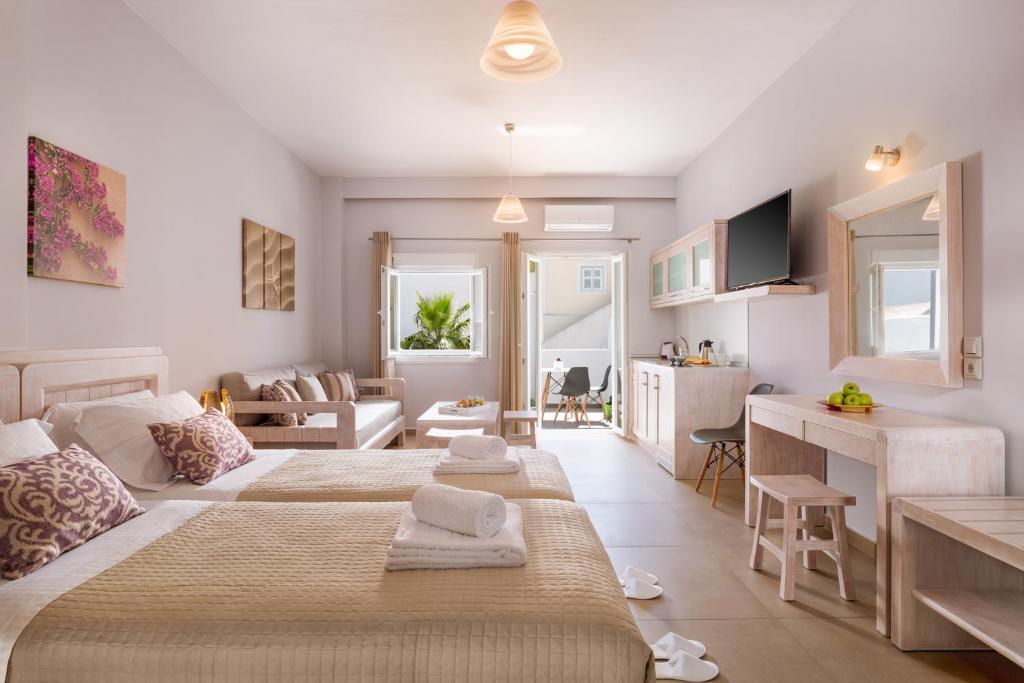 a bedroom with two beds and a living room at Mirto's Studios in Fira