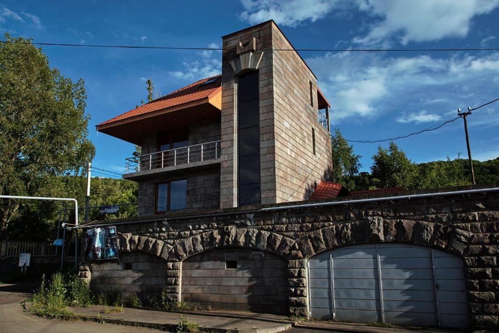 a house on a stone wall with a garage at LUXE Villa in Tsaghkadzor in Tsaghkadzor