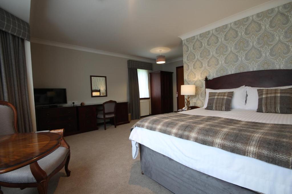 a hotel room with a bed and a table at Strathburn Hotel Inverurie by Compass Hospitality in Inverurie