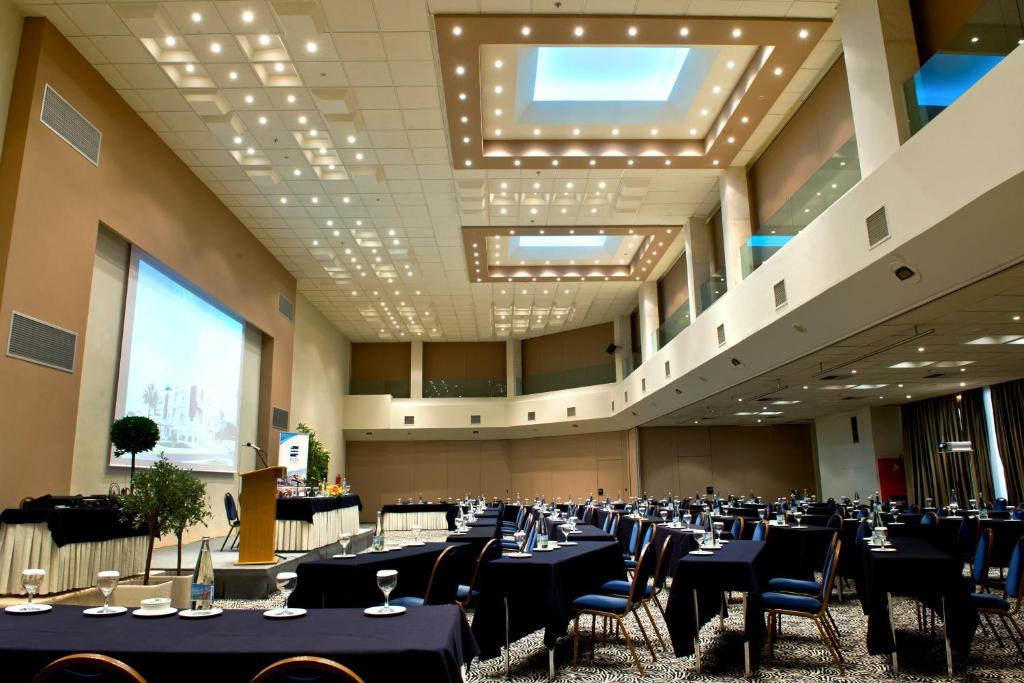 a large banquet hall with tables and chairs at Elite City Resort in Kalamata
