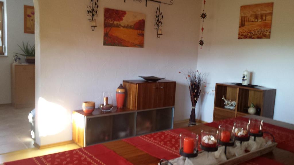 um quarto com uma mesa com velas vermelhas e um quarto com uma mesa sidx em Ferienwohnung Baur em Tussenhausen