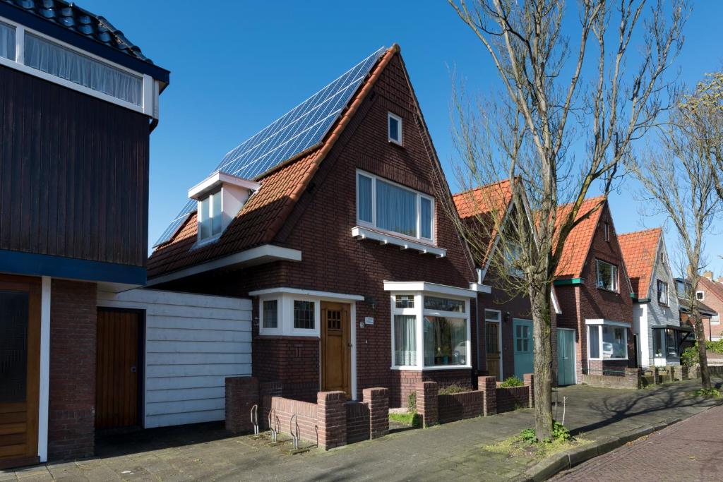 een rij huizen met zonnepanelen op het dak bij Egmond-vakantiewoningen in Egmond aan Zee