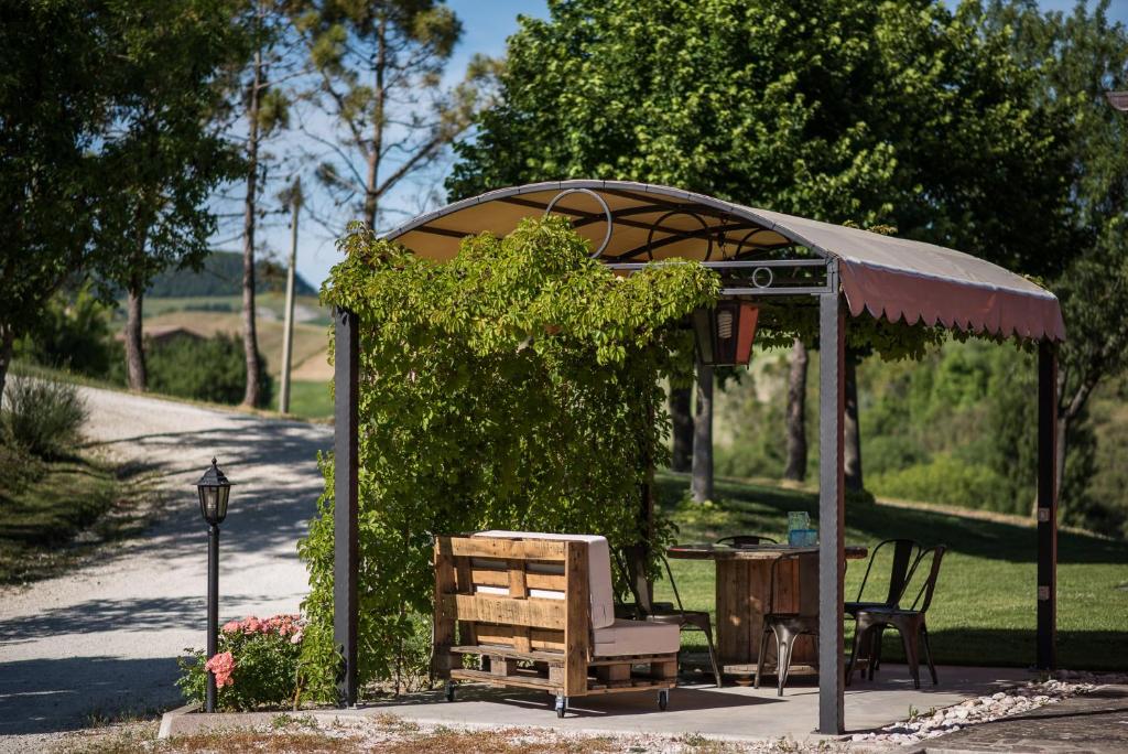 einen Pavillon mit einer Bank und einem Tisch in einem Park in der Unterkunft Casa Vacanza Il Tiglio in Sassoferrato