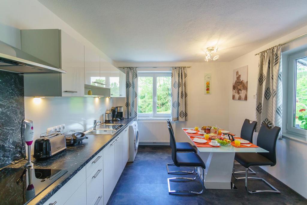 uma cozinha com uma mesa e cadeiras numa cozinha em Ferienhaus Silvia Jesse em Sankt Kanzian
