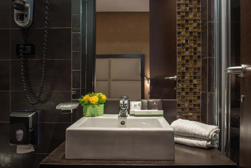 a bathroom with a white sink and a mirror at Catone District Hotel in Rome