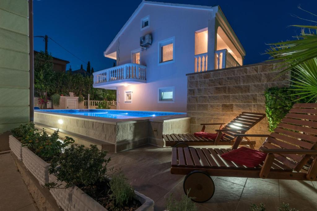 a villa with a swimming pool at night at Vila Snjezana in Trogir