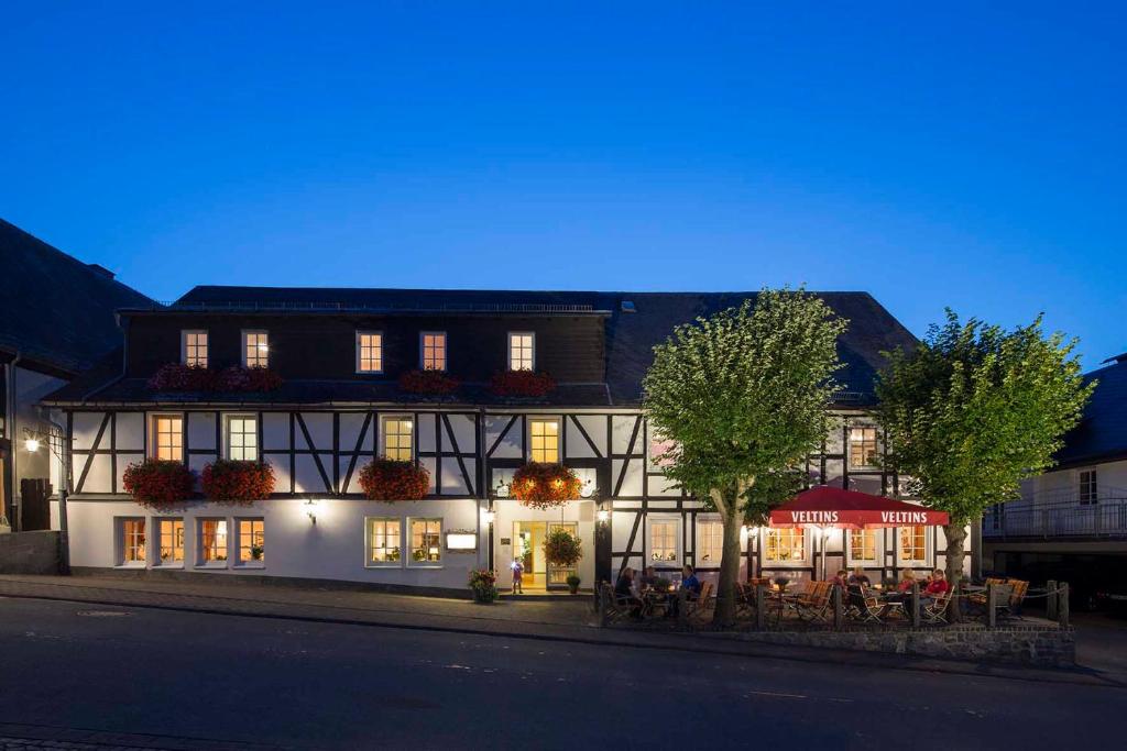 un edificio al lado de una calle por la noche en Hotel Lindenhof, en Meschede