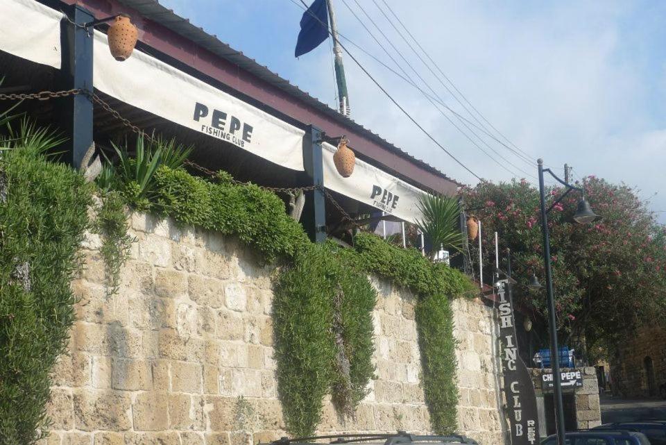 a restaurant with ivy growing on the side of a building at Byblos Fishing Club Guesthouse in Jbeil