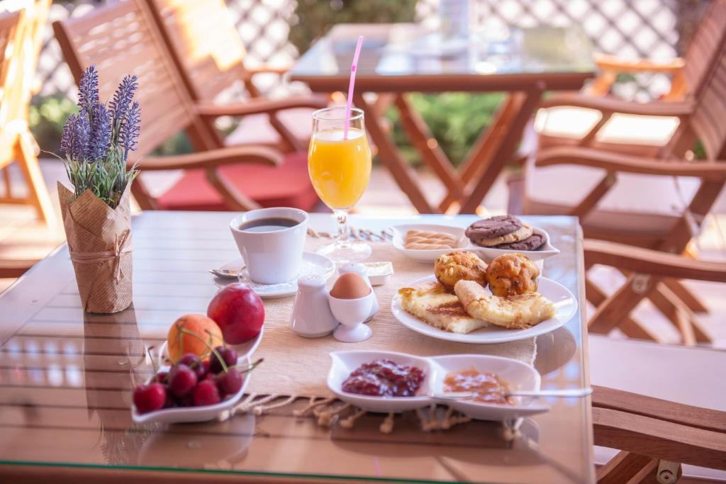 uma mesa com uma bandeja de alimentos para o pequeno-almoço e uma bebida em Hotel Vizantio em Paralia Katerinis