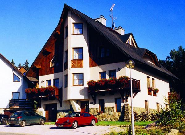 a large white building with cars parked in front of it at Pension Klondajk in Harrachov
