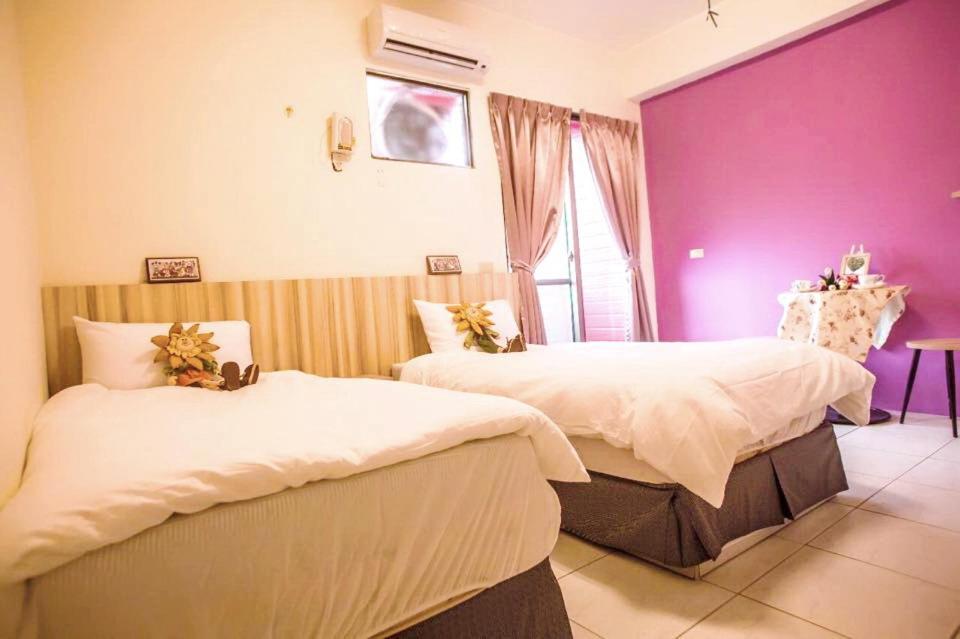 豐山村的住宿－戀戀豐田-鳥鳴民宿，一间卧室设有两张床和紫色墙壁
