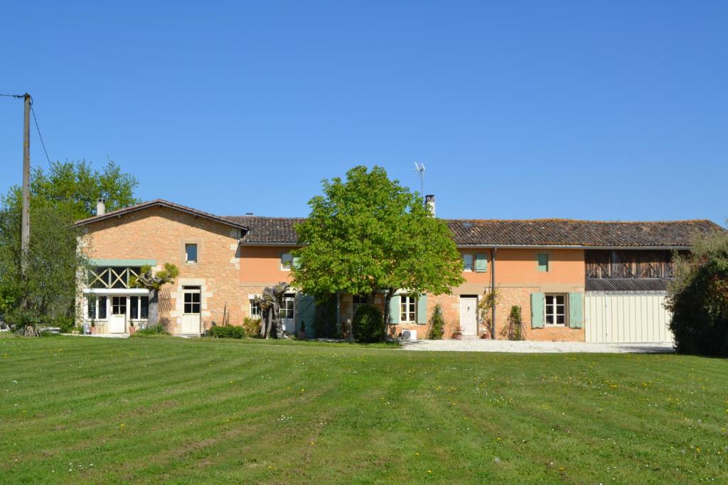a large brick house with a large yard at Ferme de Mouline in Sainte-Foy-la-Longue
