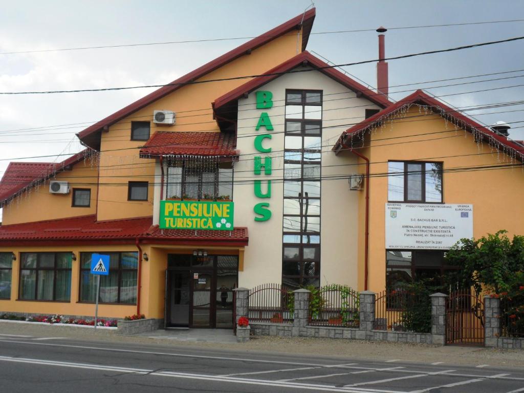 un edificio con un cartel en el costado en Pensiunea Bachus, en Piatra Neamţ