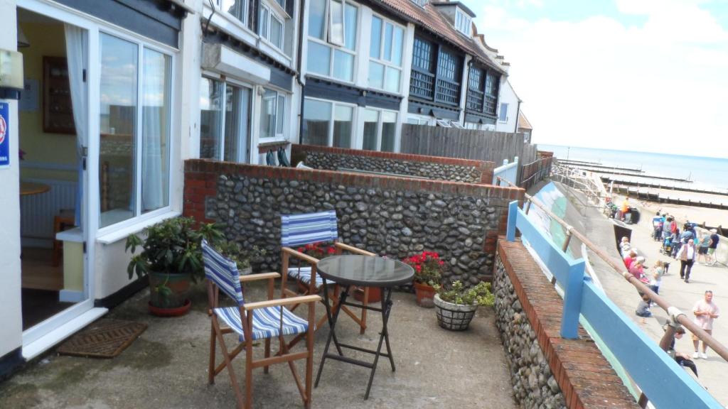 a patio with two chairs and a table on a building at Sea View 3 Promenade in Sheringham