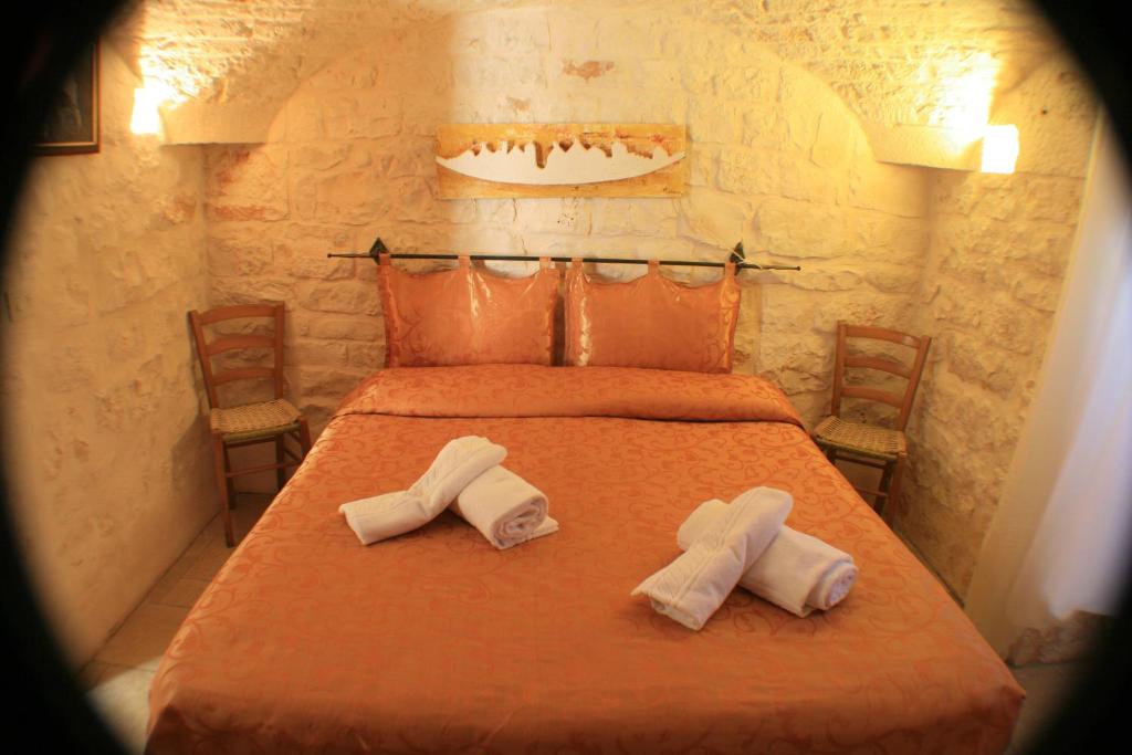 a bedroom with a bed with two towels on it at Casolare Capitolo in Cisternino