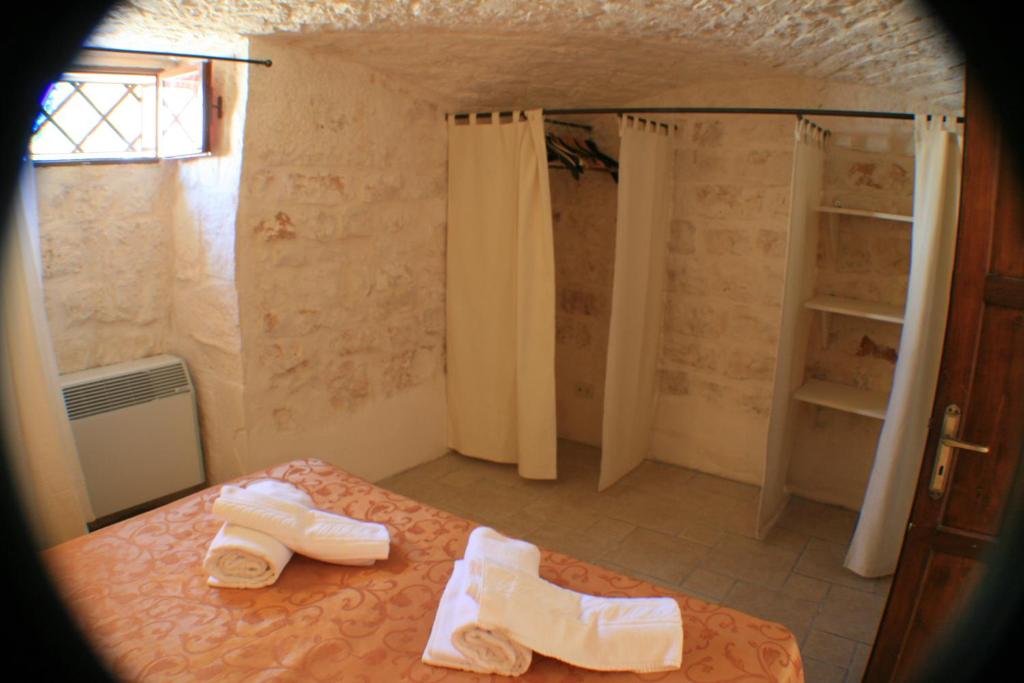 a bathroom with a bed with towels on it at Casolare Capitolo in Cisternino